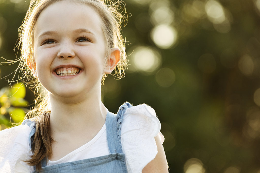 Smiling girl during a family photoshoot by Loci Photography