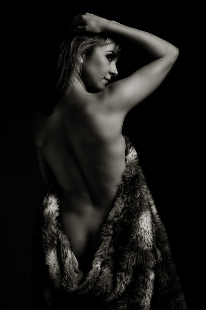 Black and white moody image of woman's back taken in studio for a boudoir shoot done by Pretoria photographer Yolandi Jacobsz of Loci PhotographP