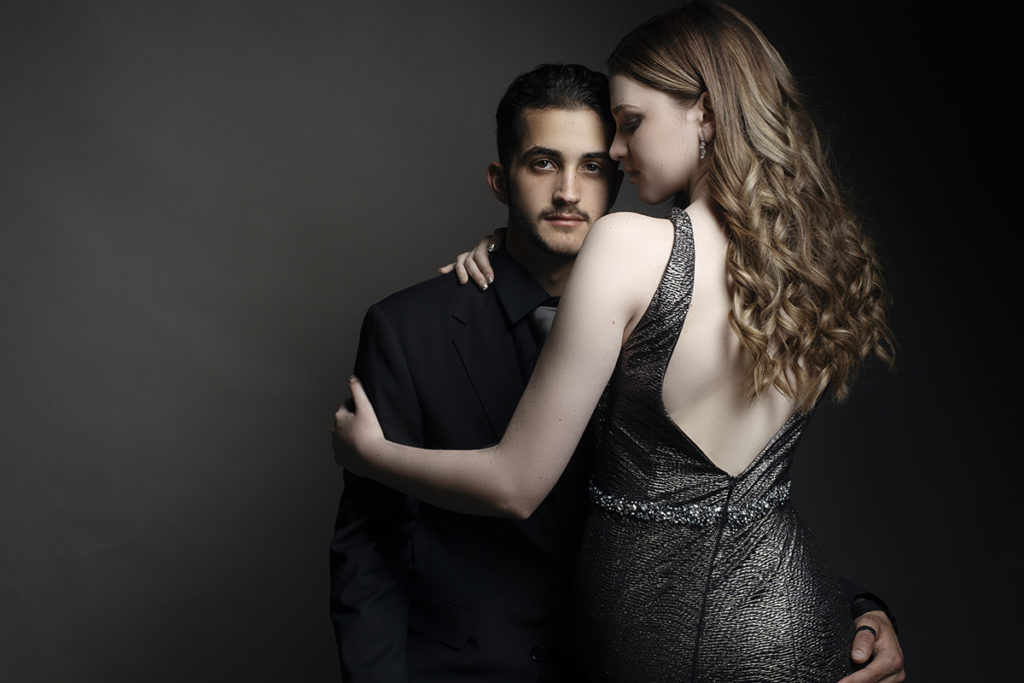 Image of girl sitting on guy's lap during a studio matric dance photoshoot by Loci Photography