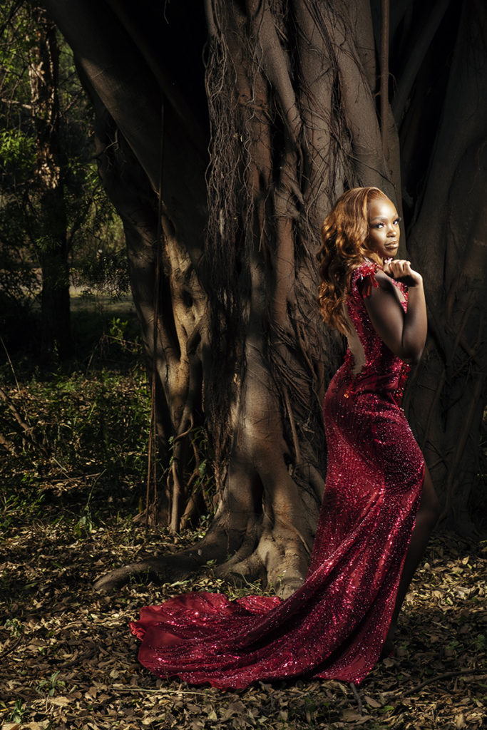 Image of young woman in dark pink glitter beaded dress taken at the Pretoria Botanical Gardens by Loci Photography