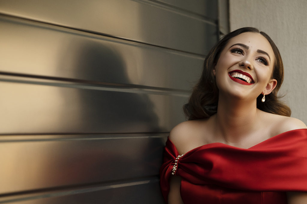 Young woman in red dress and red lips smiling during her matric dance photoshoot by Loci Photography
