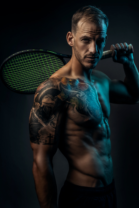 Moody fitness image of trained man with tennis racket with well shaped physique during fitness photoshoot with Loci Photography