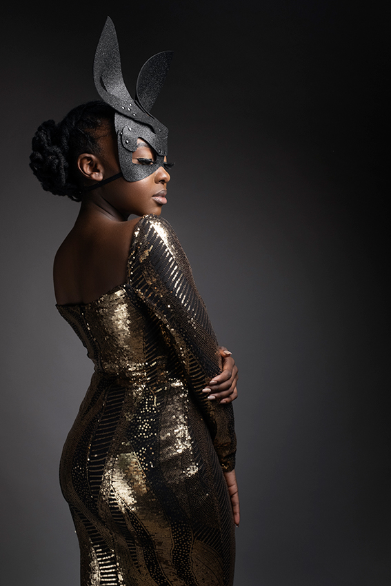 Female model in gold shimmer glitter dress with black glitter bunny mask photographed in studio by Loci Photography