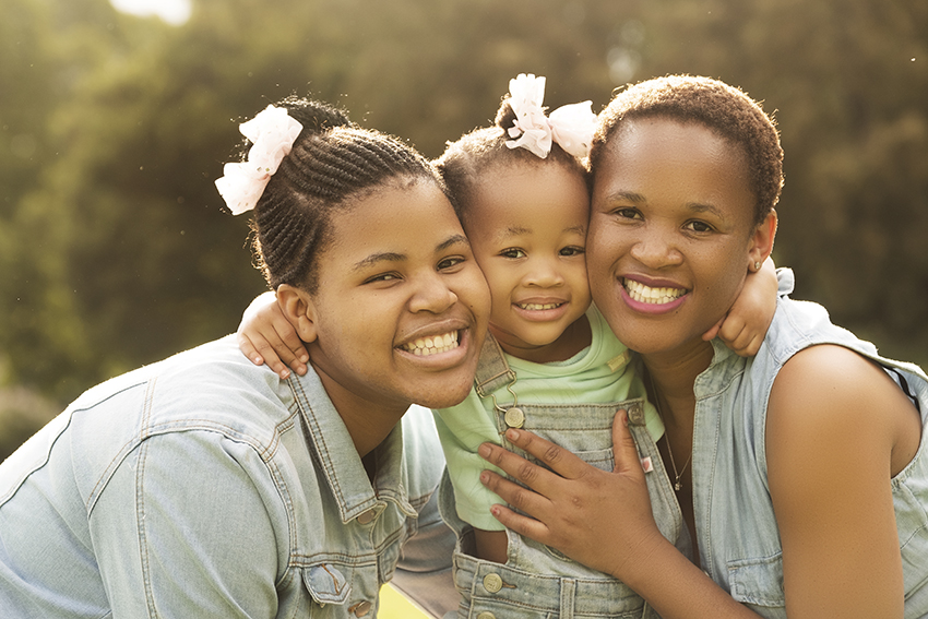 Image of smiling family in the sun captured professionally by Loci Photography in Pretoria
