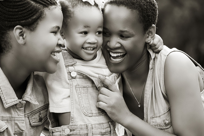 Black and white image of family smiling during their family photoshoot in Pretoria by Loci Photography